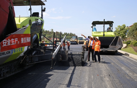 攤鋪機(jī)、壓路機(jī)等設(shè)備緊張有序運(yùn)行，高達(dá)170℃的瀝青混合料炙烤著公路人